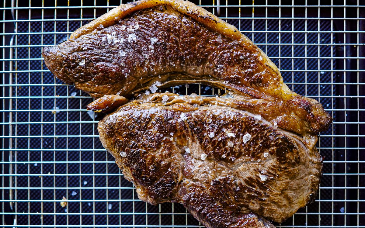A piece of seared Shimo Wagyu Rump resting on a wire reack
